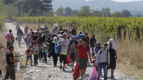 Refugiados cruzan la frontera entre Macedonia y Grecia. Foto: EFE