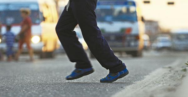 CORRIENDO PARA GANAR A LOS VEHÍCULOS Los pies de este hombre reflejan la carrera para atravesar la vía antes de que los vehículos lleguen hasta donde está el peatón. Los conductores no suelen bajar         la velocidad y confían demasiado en que los peato