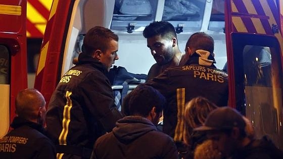 Un hombre herido se pone en un camión de bomberos junto al Estadio de Francia