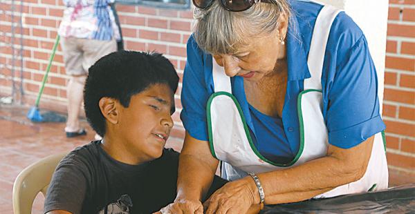 La instructora del taller, Miriam Saavedra, con uno de los niños no videntes que participan del mismo