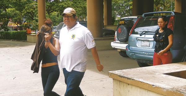 Marisol Gonzales Tapia (izquierda) es escoltada por dos policías, ayer, a la salida del palacio de justicia