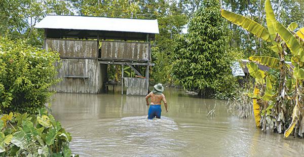 Un campesino afectado por el río Chimoré, cerca del municipio de Villa Tunari, intenta llegar a su vivienda