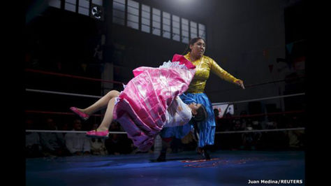 La luchadora boliviana Yenny Mamani (derecha), conocida como Martha "La Altena", y Leonor Córdova, quien lleva el apodo de Anglea "La Simpática", pelean en una exhibición en Madrid, España. 