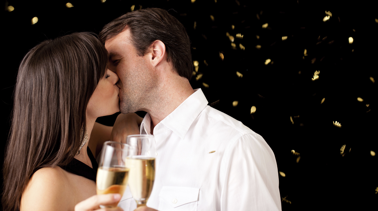 Kissing Couple Celebrating New Year with Champagne Flutes