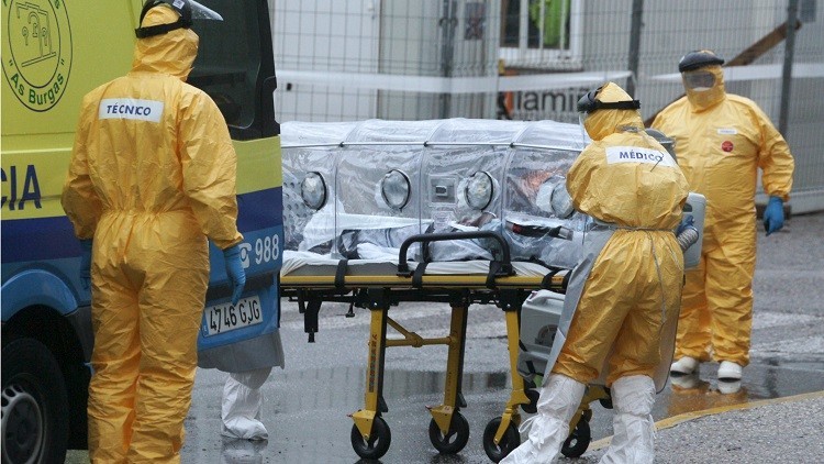 Los trabajadores médicos en la ropa de protección que transportan un posible nuevo paciente Ébola, en Vigo, España