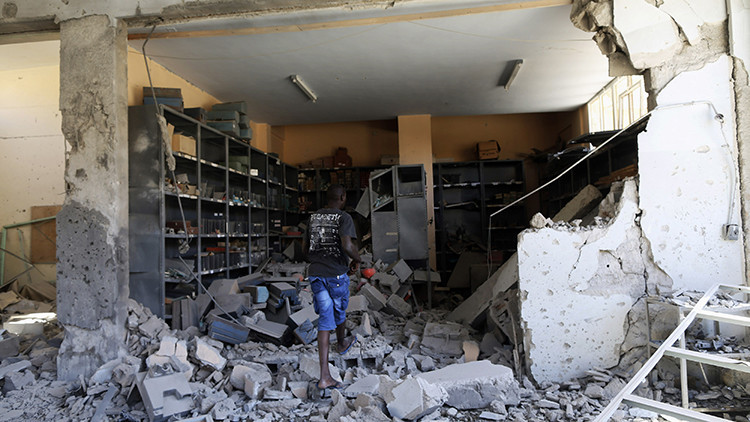 Un empleado inspecciona los daños en una institución educativa tras un bombardeo en Bengasi, el 1 de junio de 2014.