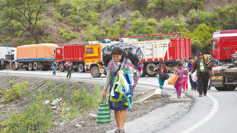 Perjuicios. Viajeros se ven obligados a caminar en uno de los puntos de bloqueo en el departamento de Chuquisaca. Foto: APG