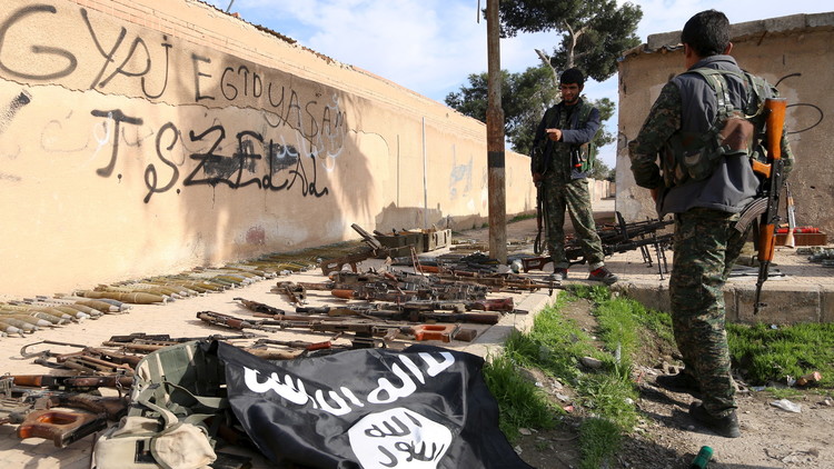 Miembros de las Fuerzas Democráticas de Siria examinan las armas y las municiones del Estado Islámico.
