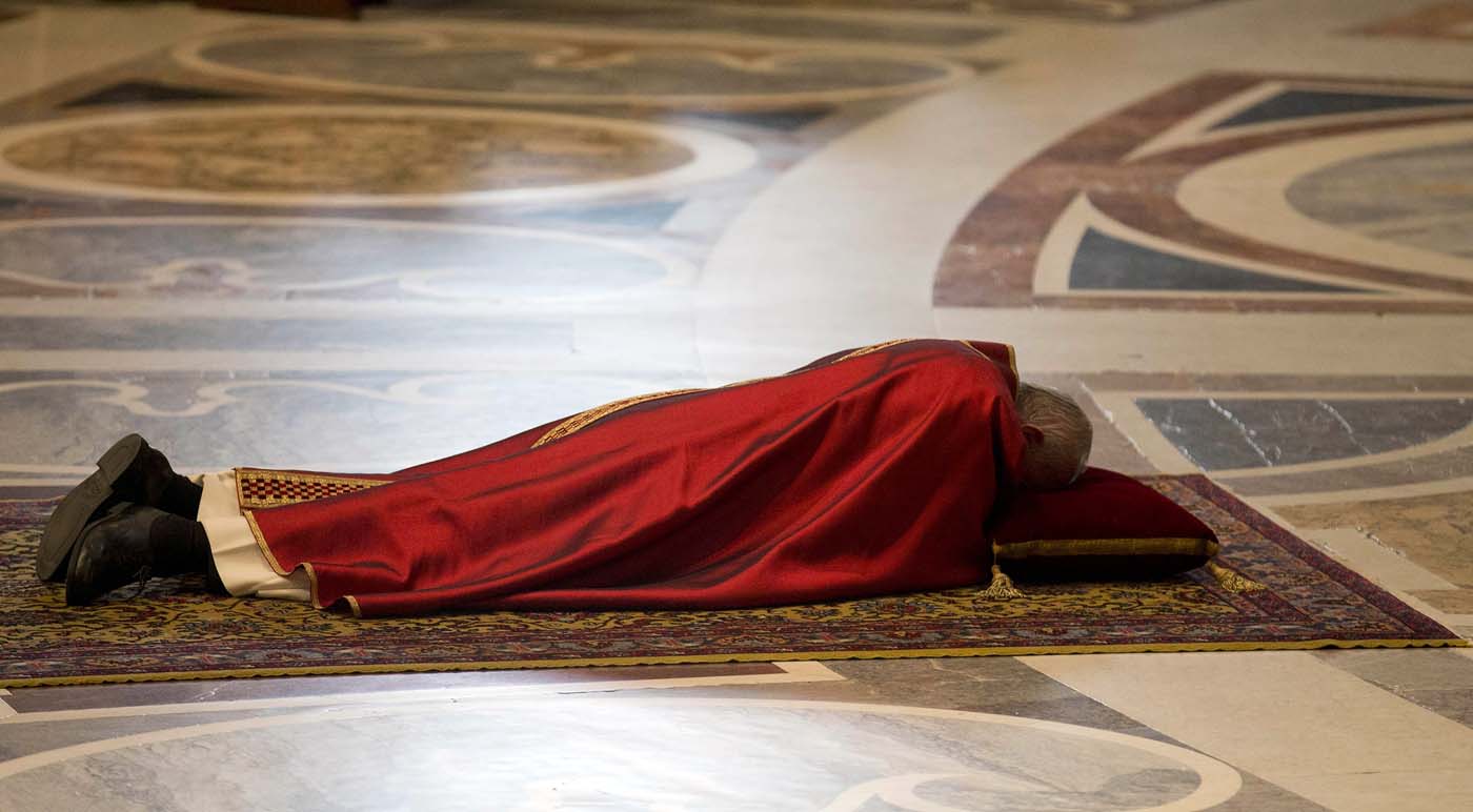 Pope Francis lies as he prays during the Celebration of the Lord's Passion in Saint Peter's Basilica at the Vatican March 25, 2016. REUTERS/Alessandra Tarantino/Pool