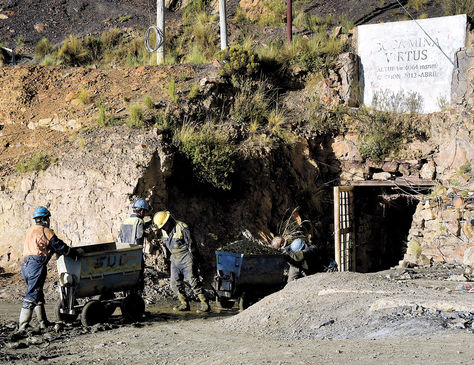 Mineros sacan carros llenos de roca en la bocamina Virtus de Amayapampa.
