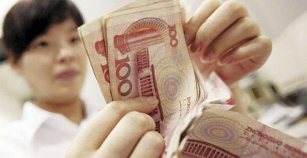 Una mujer muestra billetes de la moneda china. La devaluación abarata los productos chinas en el mundo