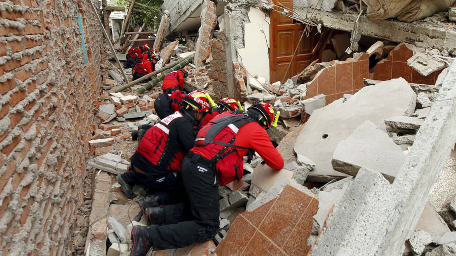 Bomberos supervisan los escombros de una vivienda en búsqueda de sobrevivientes. AP