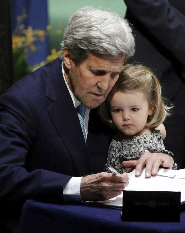 El secretario de Estado de EE.UU., John Kerry (i), sostiene a su nieta, Isabelle Dobbs-Higginson, mientras firma el Acuerdo de París en la sede de la Naciones Unidas de Nueva York (EE.UU.)
