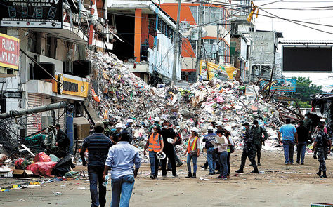 Destrucción. Escombros en media calle flanquean edificios afectados en el barrio Tarqui, en la ciudad de Manta, al norte del Ecuador.  Foto: EFE