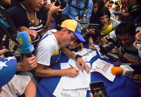 El líder de la oposición venezolana y gobernador del estado de Miranda, Henrique Capriles, firma el formulario para activar el referéndum sobre la reducción de mandato del presidente Nicolás Maduro corta, en Caracas.