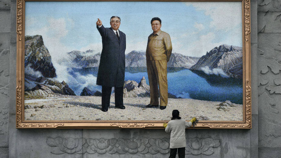 Una mujer limpia un gran mosaico que muestra los retratos de los antiguos líderes Kim Il-sung y Kim Jong-il en el Estudio de arte Mansudae en Pionyang (Corea del Norte) (Efe)