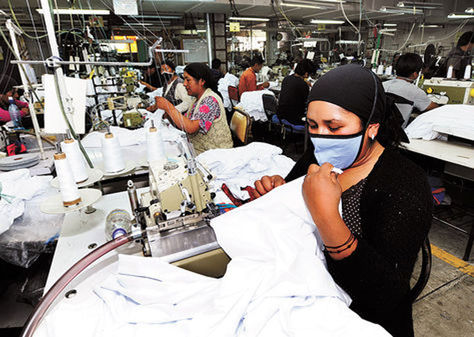 Varios empleados realizan la confección de prendas de vestir en una de las plantas de Enatex.
