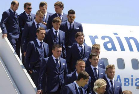 La selección de Ucrania, a su llegada al aeropuerto de Marsella, Francia. Azul marino, con chaleco y pañuelo en la solapa junto al escudo, es el traje de calle elegido por el equipo.