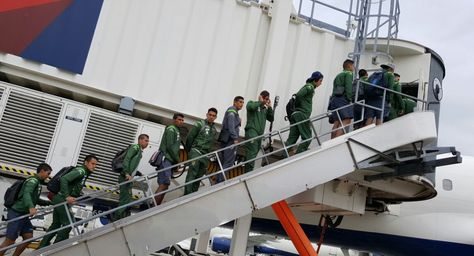 Los jugadores de la selección abordan el avión para viajar a Seattle.