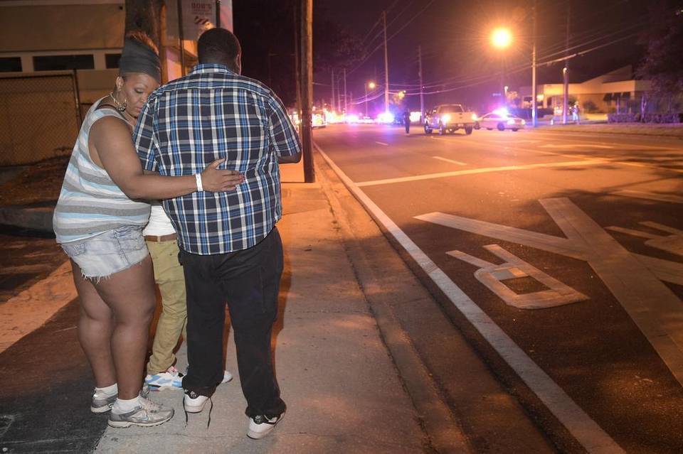 Transeúntes esperan en la calle tras el tiroteo múltiple en el club nocturno Pulse en Orlando, Florida.