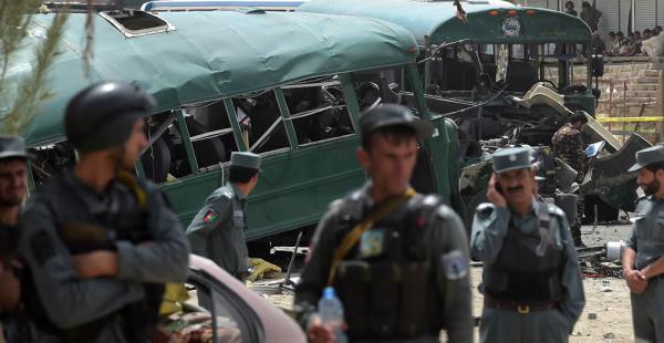 El personal de seguridad afganas se reúne cerca de los restos de los autobuses que llevaban cadetes de la Policía