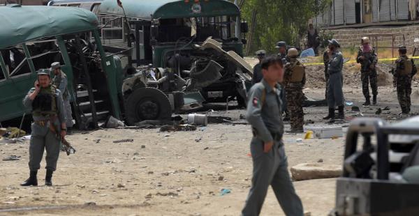 El personal de seguridad afganas se reúne cerca de los restos de los autobuses que llevaban cadetes de la Policía