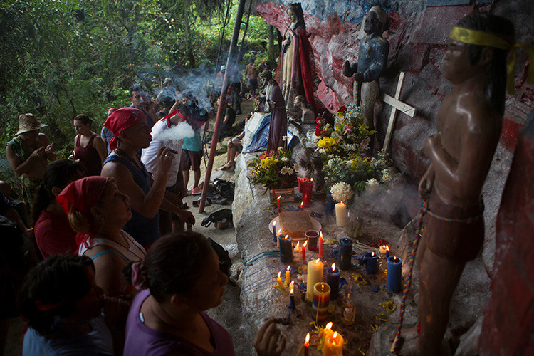 Los devotos rezan, fuman puros y encienden velas en el santuario de María Lionza en la montaña de Sorte en las afueras de Chivacoa , en el estado de Yaracuy