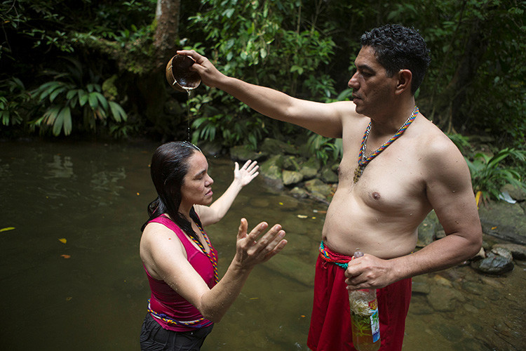 Una mujer recibe un baño de purificación en el pozo de San Juan del Dinero, en la montaña de Sorte en las afueras de Chivacoa , en el estado de Yaracuy , Venezuela