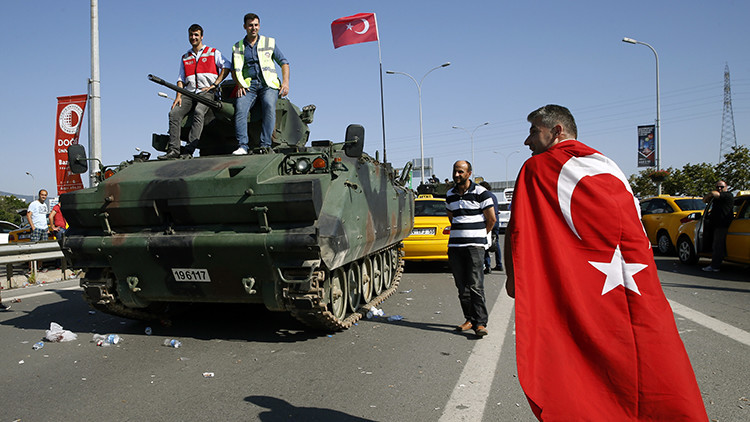 Un hombre pasa junto a un vehículo militar cerca del aeropuerto Sabiha Gokcen de Estambul, Turquía.