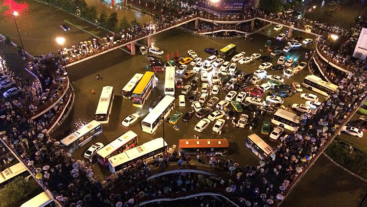 Vehículos varados en un cruce de caminos durante una fuerte lluvia en Xi