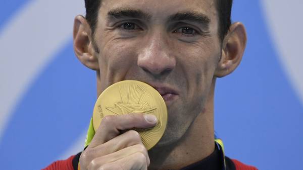 USA's Michael Phelps poses with his gold medal on the podium of the Men's 200m Individual Medley Final during the swimming event at the Rio 2016 Olympic Games at the Olympic Aquatics Stadium in Rio de Janeiro on August 11, 2016. / AFP PHOTO / CHRISTOPHE SIMON