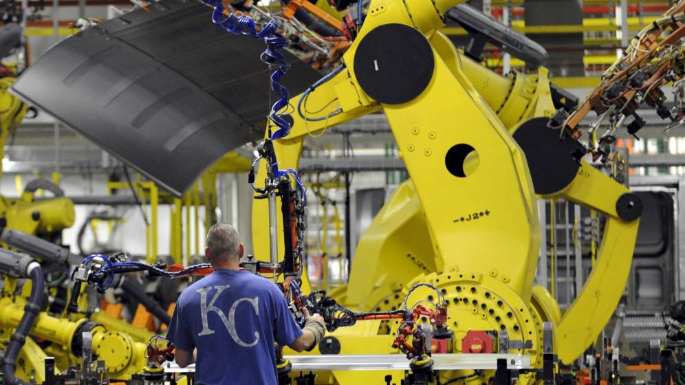 Foto: Un empleado y un robot, en la fábrica de Ford en la ciudad de Kansas.