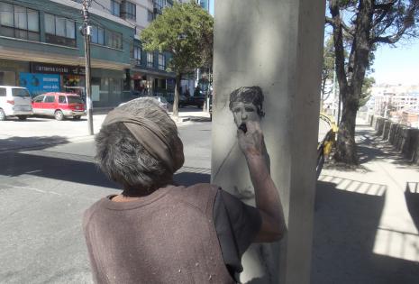 Un artista callejero dibuja el rostro de Donald Trump.
