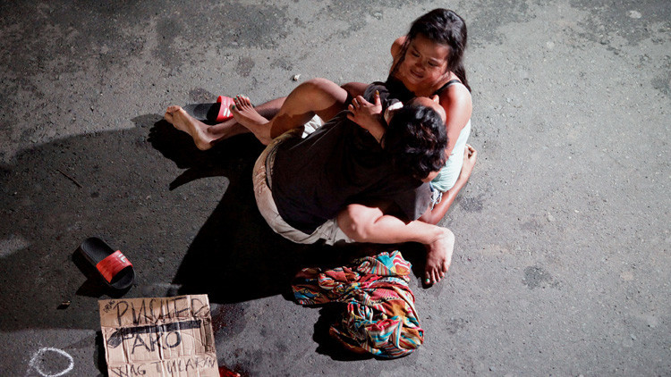 Una mujer junto al cuerpo de su pareja, muerto en una serie de asesinatos relacionados con las drogas en la ciudad de Pásay, Filipinas