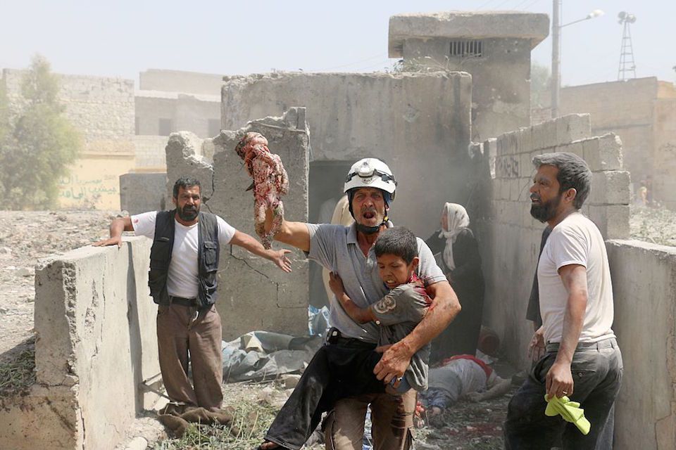 EDITORS NOTE: Graphic content / A Syrian rescue worker evacuates a dead baby and a wounded child as civilians search for victims in the Maadi district of eastern Aleppo after regime aircrafts reportedly dropped explosive-packed barrel bombs on August 27, 2016. At least 15 civilians were reported killed when two bombs fell several minutes apart, near a tent where people were receiving condolences for those killed this week. / AFP / AMEER ALHALBI (Photo credit should read AMEER ALHALBI/AFP/Getty Images)