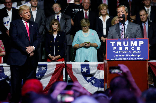 Donald Trump atiende al discurso de Nigel Farage durante un mitin en Jackson. (Reuters)