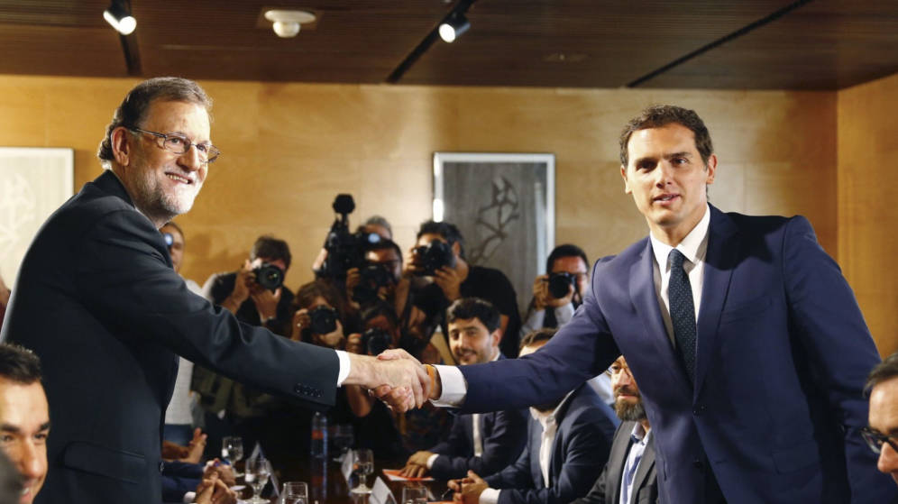 Foto: El presidente del Gobierno, Mariano Rajoy, y el líder de Ciudadanos, Albert Rivera, sellan el pacto con un apretón de manos. (EFE)