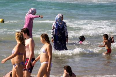 Cubiertas. Una imagen habitual en Israel. En esta playa de Tel Aviv, mujeres musulmanas se bañana en el mar. /AP