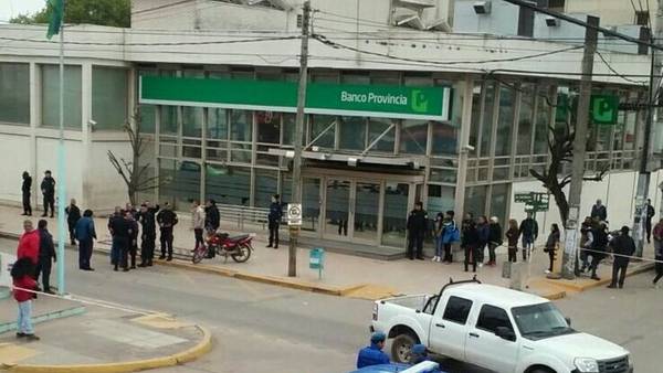 Policías y vecinos tras una salidera en el Banco Provincia de General Rodríguez. (@solorzanoRodri)
