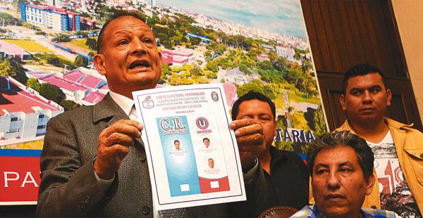 El presidente de la Corte Electoral Permanente, Róger Guzmán, muestra la papeleta de sufragio