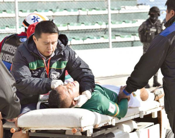 EL MÉDICO DE LA VERDE, FABIÁN PACHECO (I), ATIENDE AL JUGADOR JHASMANY CAMPOS, EN EL PARTIDO ANTE PERÚ EN AGOSTO. APG