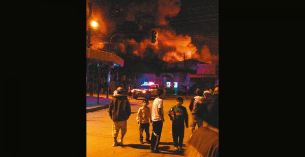 Los pobladores observan de lejos las llamas que salen del mercado