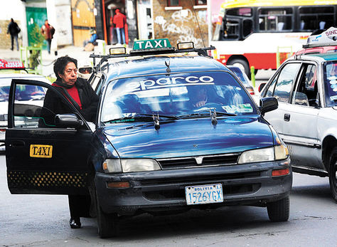 Una mujer aborda un taxi en el centro paceño. Foto: Archivo La Razón