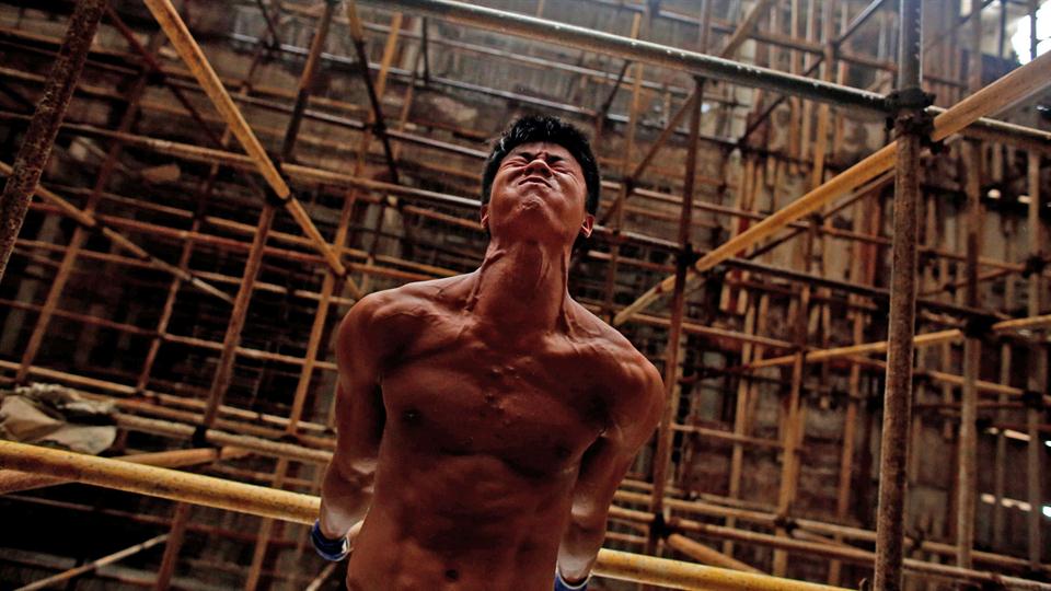 Shi Shenwei, realiza su rutina de barra fija, en un andamio de una obra de construcción en un templo budista, en el pueblo de Huangshan, cerca de Quanzhou, provincia de Fujian, China