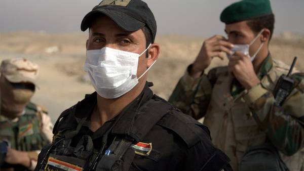 Barbijos. Soldados iraquíes se protegen del humo tóximo que emana cerca de la ciudad de Awsaja, en Irak, este sábado. I/AP