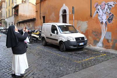 Una monja toma una foto del mural del Papa Francisco, realizado por Maupal, poco antes de ser borrado. / AFP