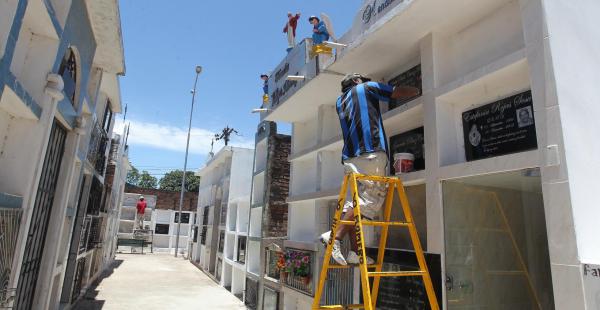 Los albañiles aumentan sus ingresos pintando tumbas y mausoleos, como en el cementerio Hamacas