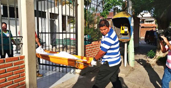 Efectivos de la división de Homicidios retiran el cuerpo del chico del centro de salud municipal San Luis, cerca de la av. 26 de Febrero