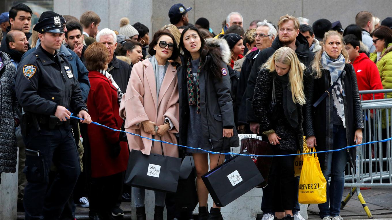 La policía usando una cinta para prohibir que la gente cruce en rojo el semáforo durante el black friday. Foto: Reuters / Andrew Kelly