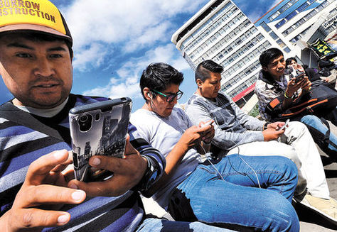 Jóvenes acceden a las redes sociales a través de sus celulares inteligentes en la plaza Eliodoro Camacho. Foto: Ángel Illanes - archivo